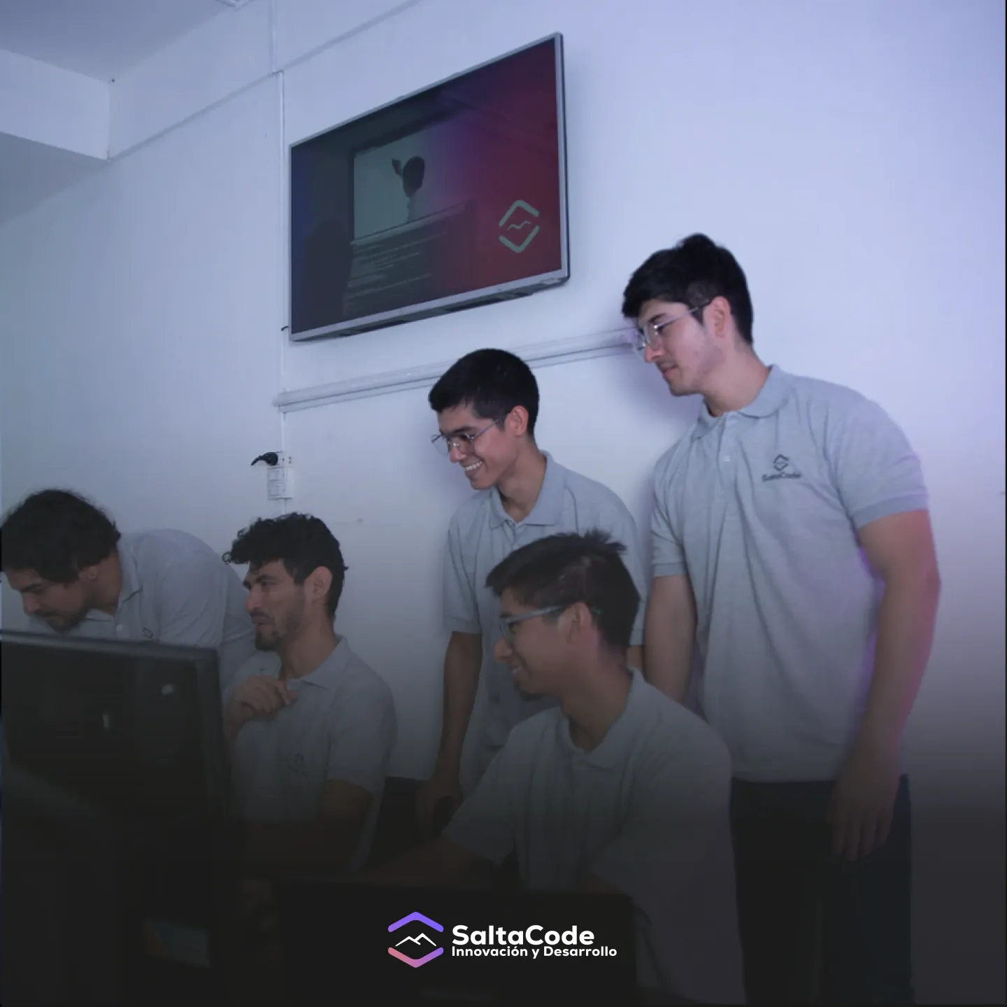 Equipo de SaltaCode colaborando frente a una computadora